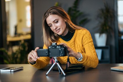 Young woman preparing camera for vlogging.